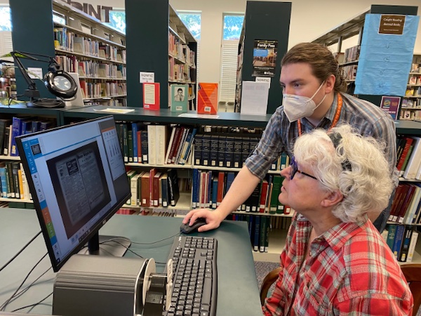 Person helping with the microfilm reader